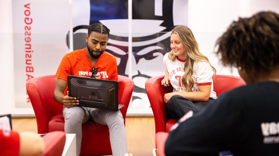 Students looking at a laptop in the Kimbrough Lounge